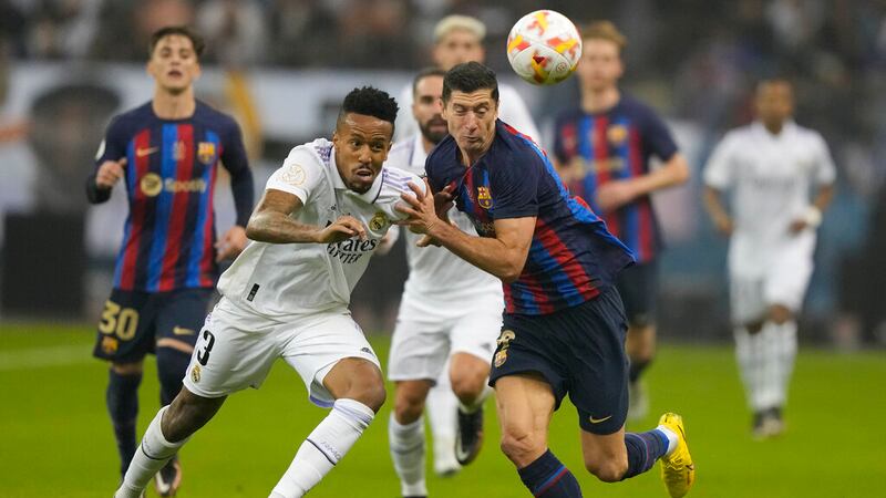 Eder Militao (izquierda) del Real Madrid y Robert Lewandowski del Barcelona pugnan por el...